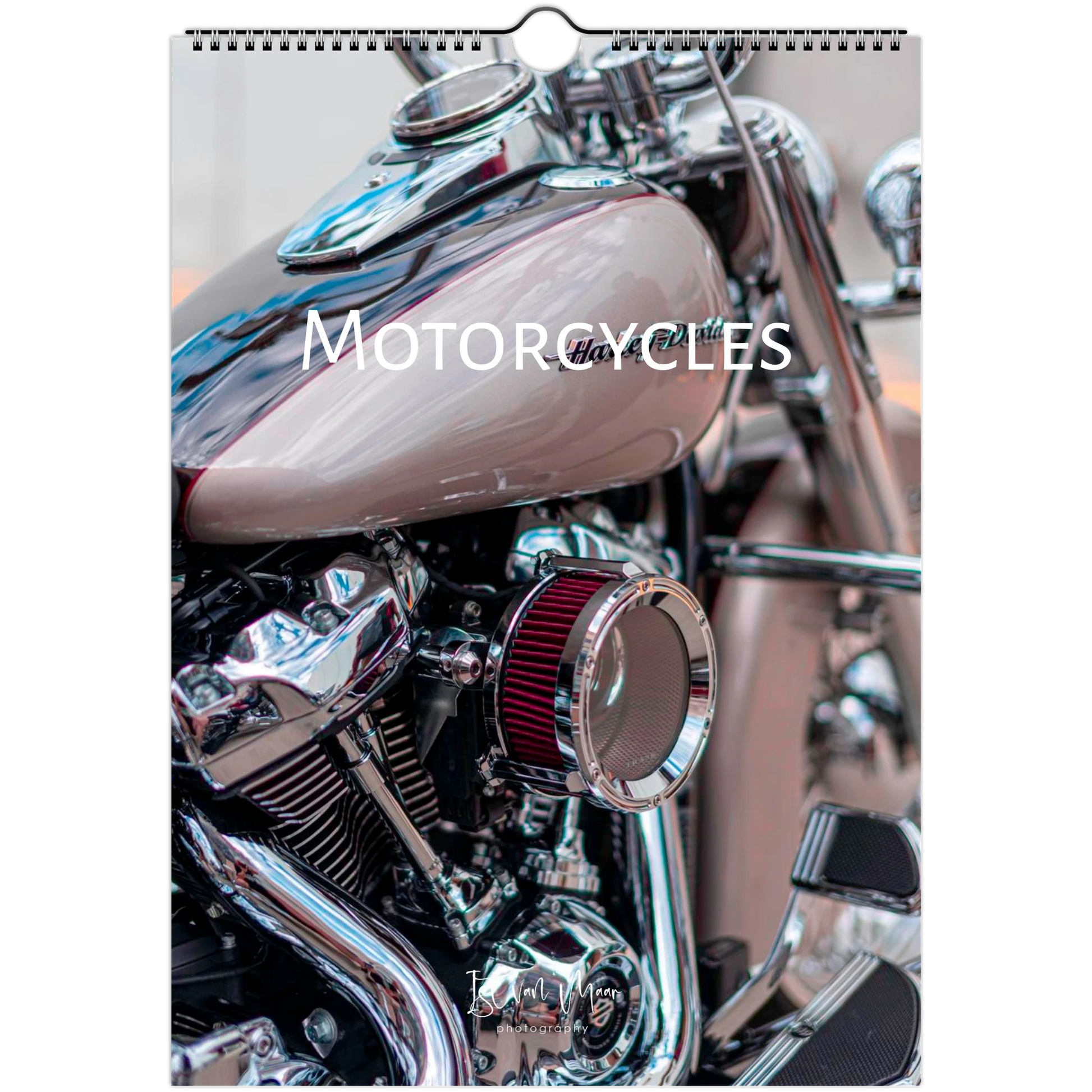 A wall calendar page featuring a close-up photograph of a motorcycle, with the word 'MOTORCYCLES' printed across the center. The calendar has a white border and a hanging tab at the top.