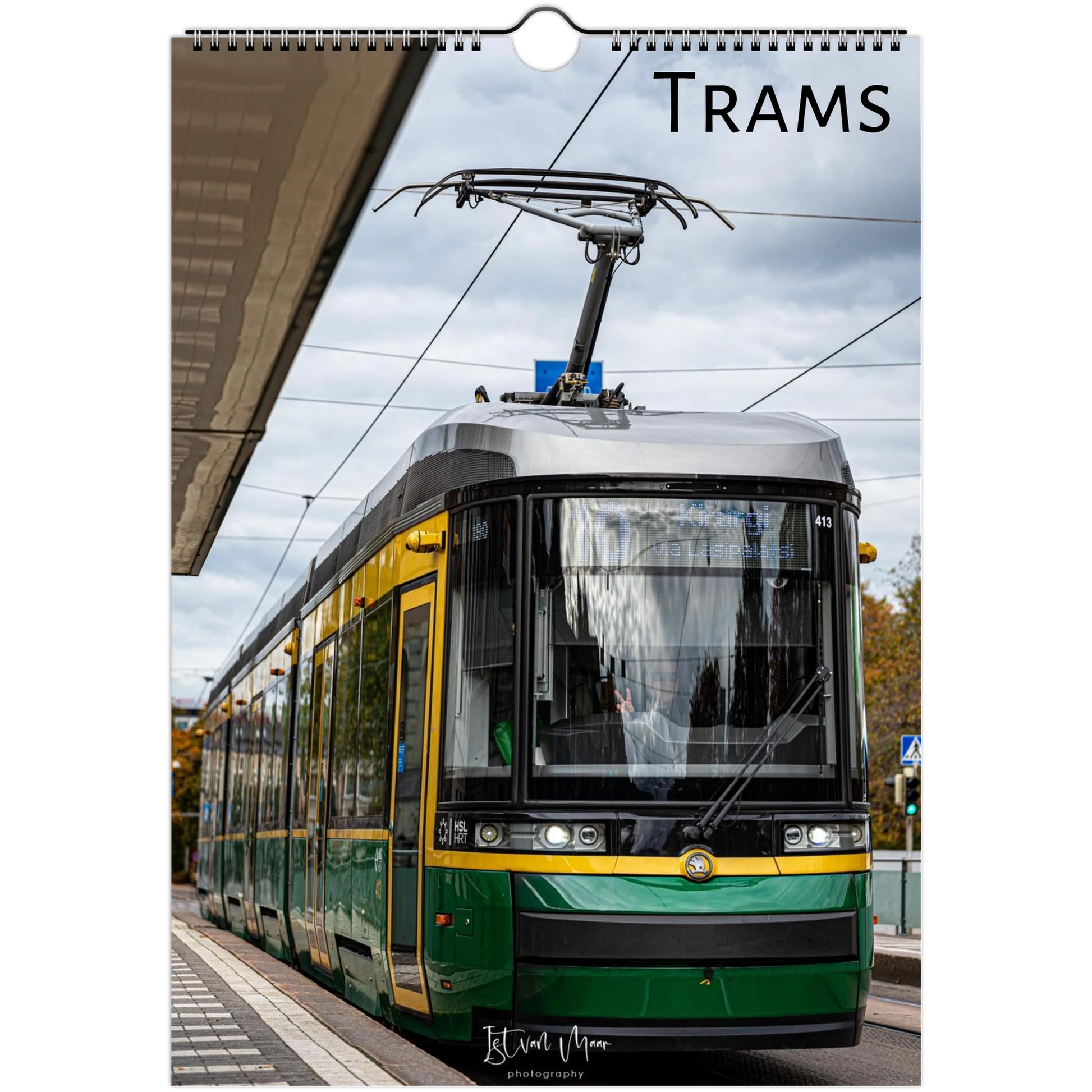 A spiral-bound wall calendar or print featuring a photograph of a green and yellow tram at a station platform under an overcast sky, with the word "TRAMS" printed at the top. Available in A4, A3, LT and LG US sizes.