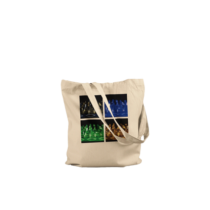 A natural canvas tote bag with dual shoulder straps, featuring a square graphic print on the front showing four panels of glowing chess pieces in different colors (yellow, blue, green, orange) against a black background.