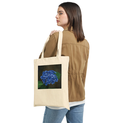 Model carrying a natural canvas tote bag printed with a blue hydrangea photograph, Classic style