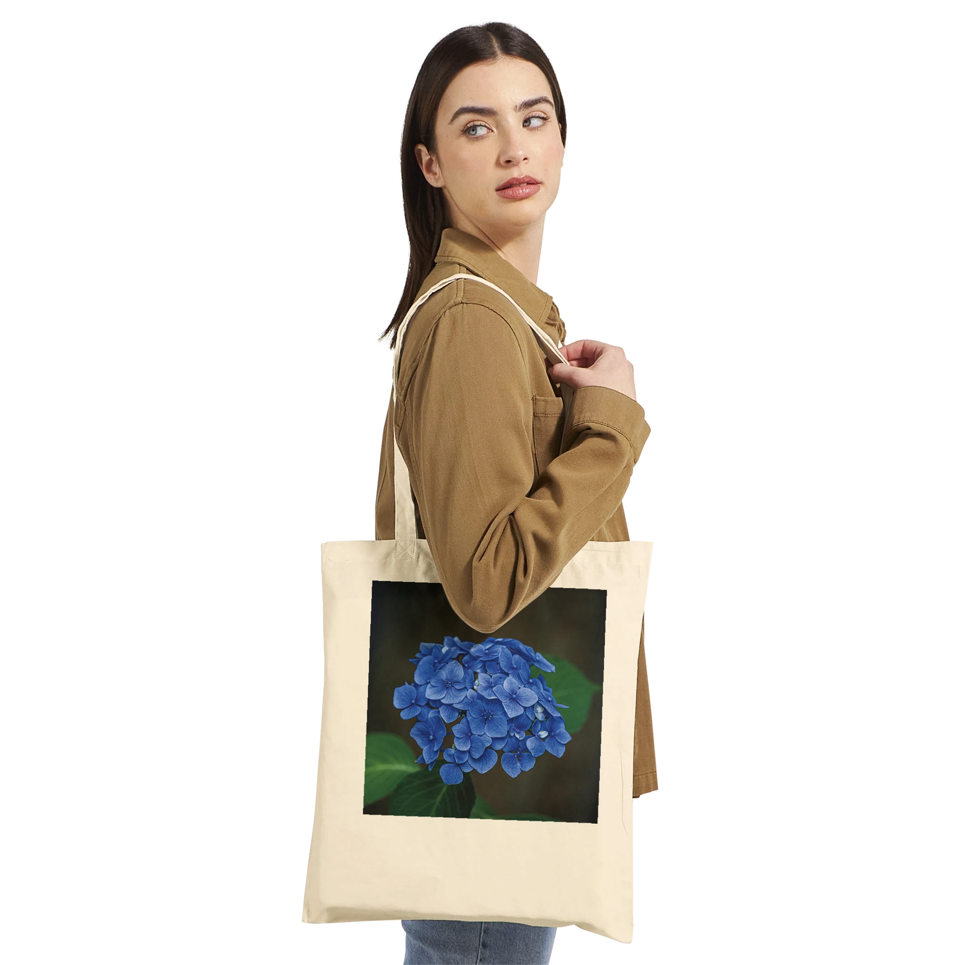 Model carrying a natural canvas tote bag printed with a blue hydrangea photograph, Premium style