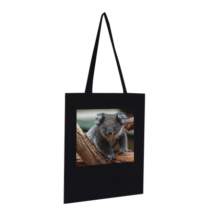 Black canvas tote bag printed with a koala photograph, Premium style, hanging profile view