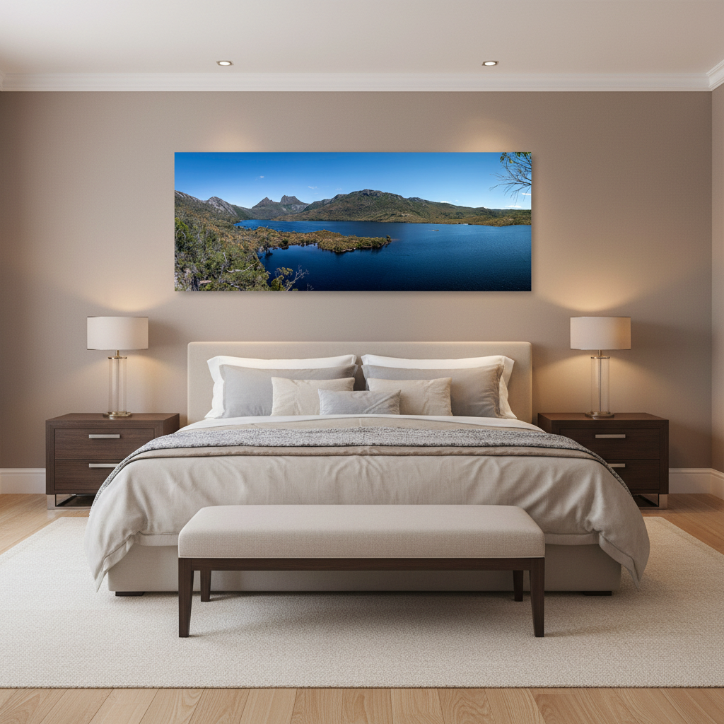 A large panoramic canvas print of a scenic Cradle Mountain landscape is displayed on a beige wall above a neatly made bed in a modern, symmetrically styled bedroom.