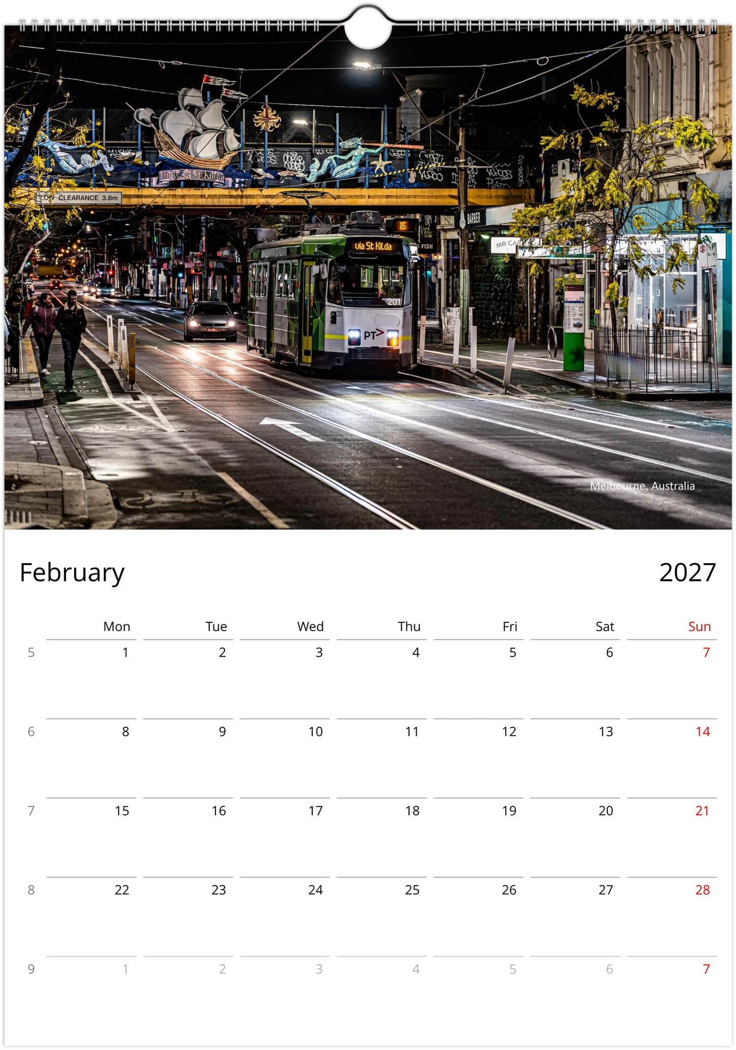 Green Melbourne tram on a quiet wet city street at night passing under a decorative overhead bridge with street art - Melbourne Australia - Trams After Dark wall calendar February