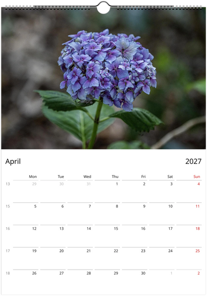 Calendar page for April 2027 with a purple flower on a blurred natural background