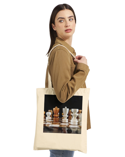 Woman carrying The King Stands Alone chess tote bag — Premium Natural