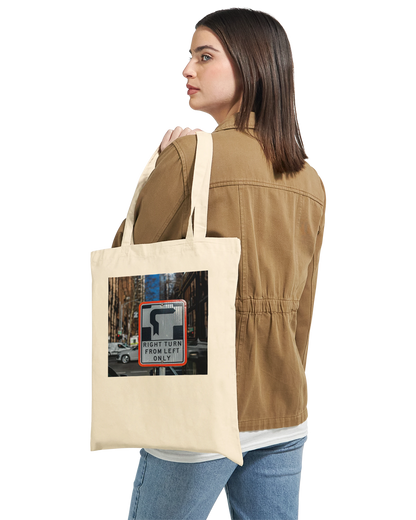 Model carrying the Premium Natural Right Turn street sign tote bag over one shoulder, lifestyle shot