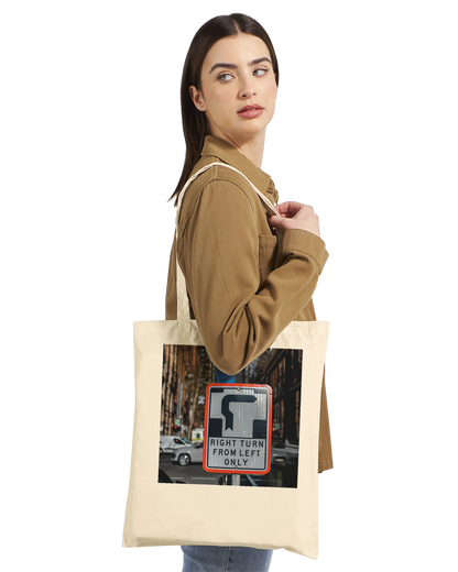 Model wearing the Premium Natural Right Turn street sign tote bag, side profile lifestyle shot