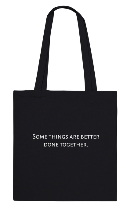 Three Pelicans canvas tote bag, black, back view with printed quote: Some things are better done together.