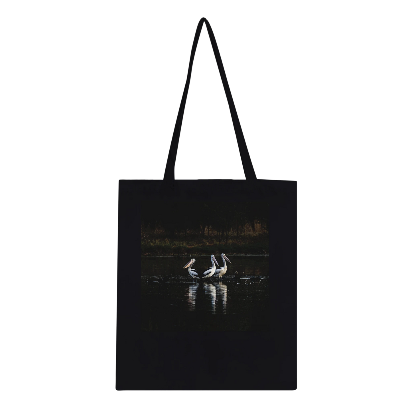 Three Pelicans canvas tote bag, Classic Black, front — fine art photograph of three pelicans standing together in still water at dusk
