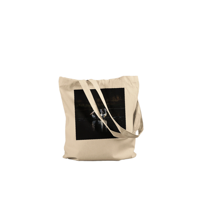 Three Pelicans canvas tote bag, natural, front view laid flat with straps draped — fine art photograph of three pelicans standing together in still water at dusk