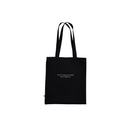 Three Pelicans canvas tote bag, Premium Black, front — fine art photograph of three pelicans standing together in still water at dusk